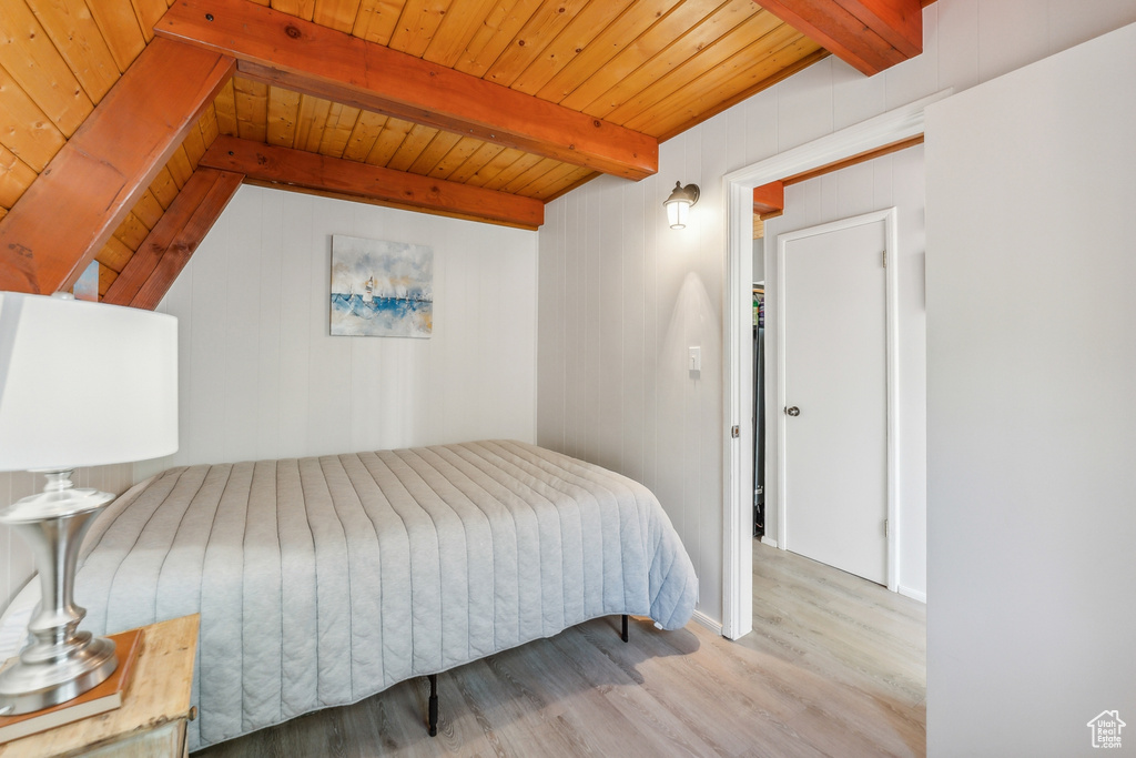 Bedroom with beamed ceiling, wooden ceiling, and wood-type flooring