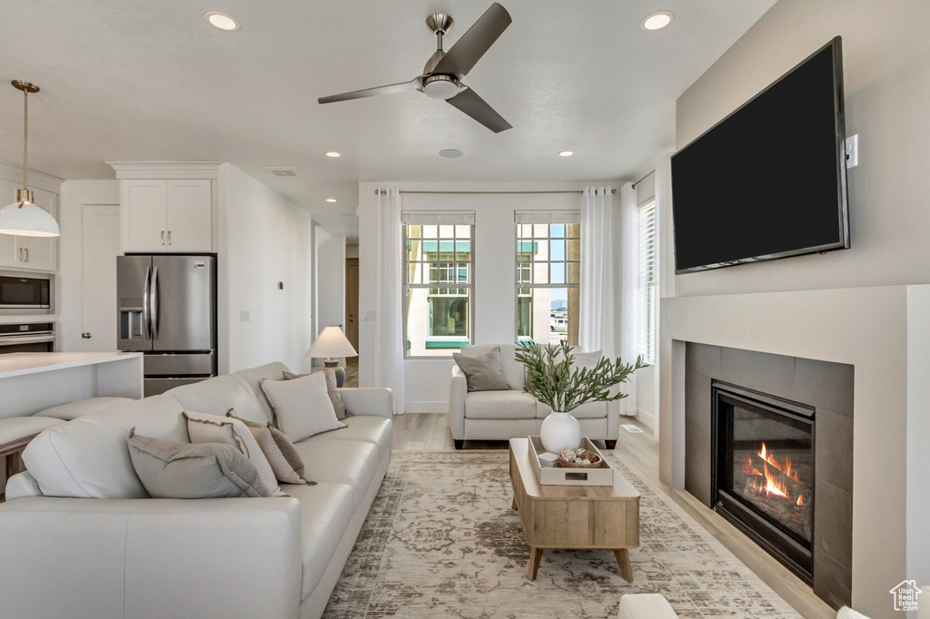 Living room with light hardwood / wood-style floors and ceiling fan