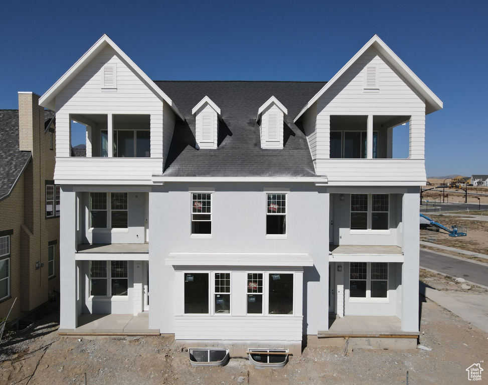 View of front of property with a patio and a balcony