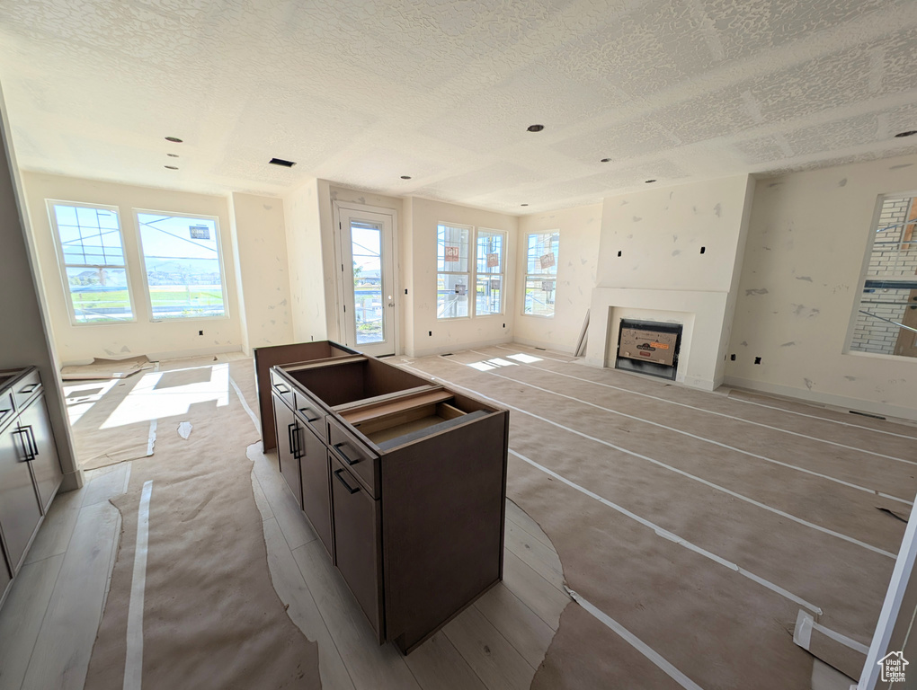 Kitchen featuring a textured ceiling, plenty of natural light, and a kitchen island