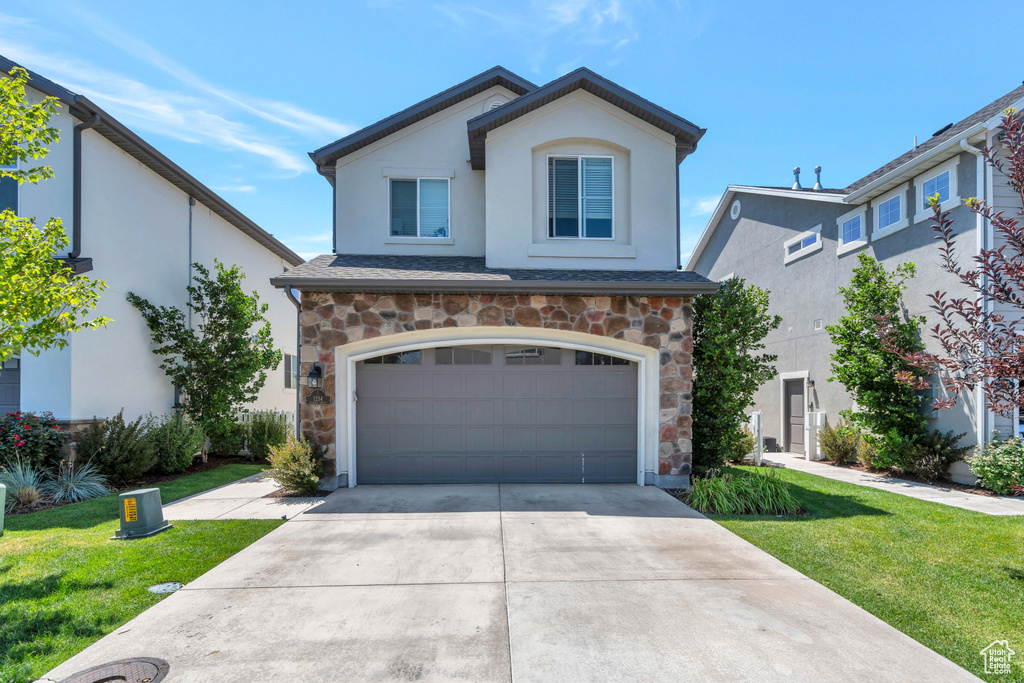 View of front of house featuring a garage and a front lawn