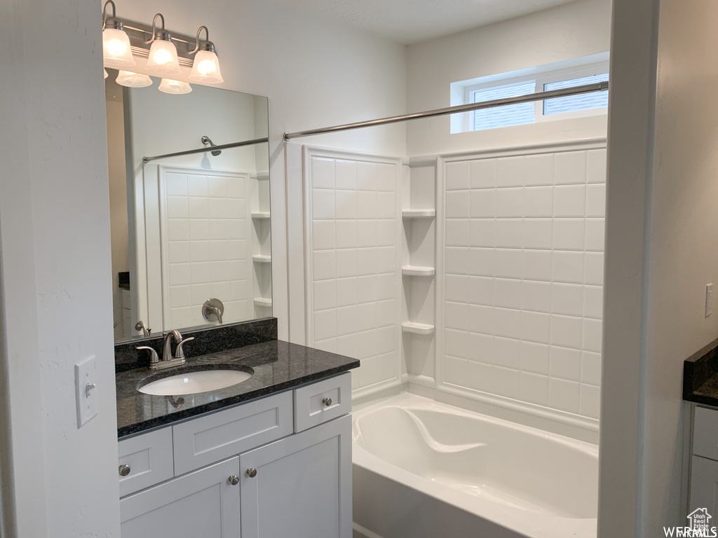 Bathroom featuring vanity and tiled shower / bath