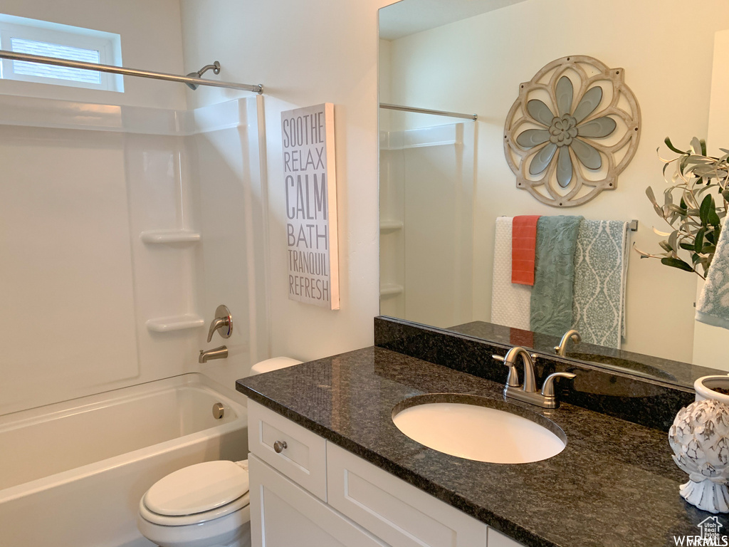 Full bathroom featuring vanity, toilet, and washtub / shower combination