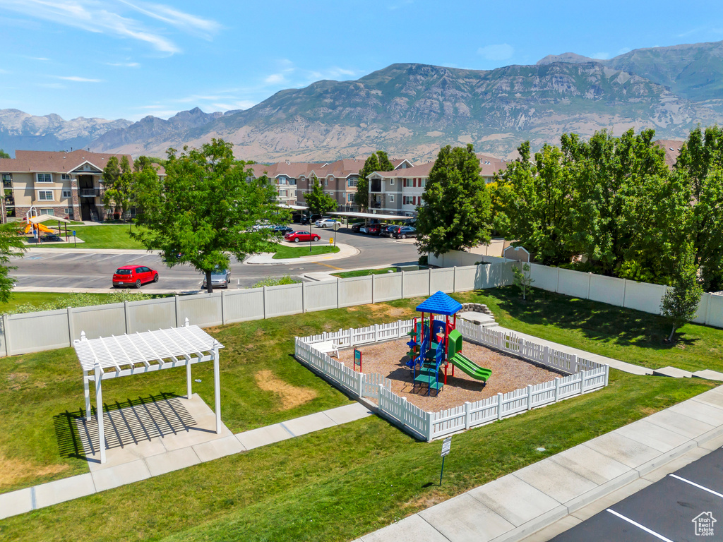 View of community with a playground, a lawn, and a mountain view