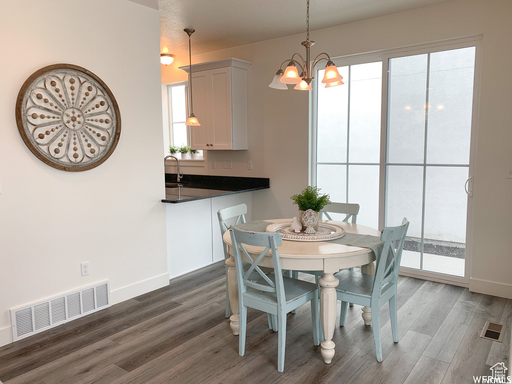 Dining room with a notable chandelier and wood-type flooring