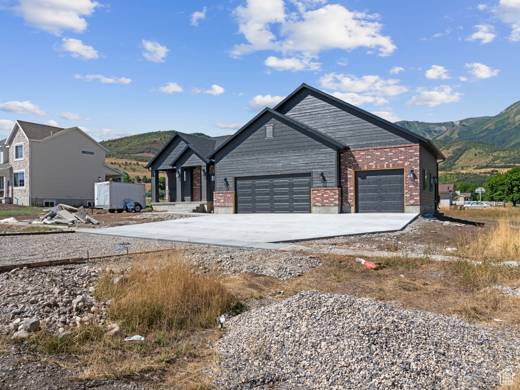 View of front facade featuring a garage and a mountain view