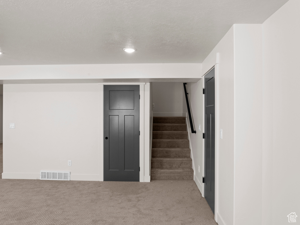 Interior space with carpet and a textured ceiling