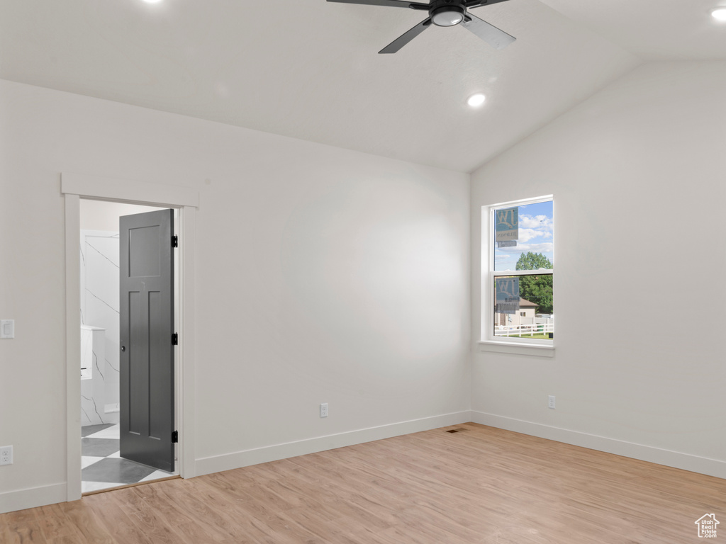 Spare room with ceiling fan, light wood-type flooring, and lofted ceiling