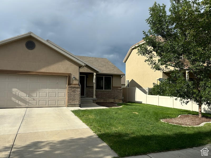 View of front of home featuring a front lawn and a garage