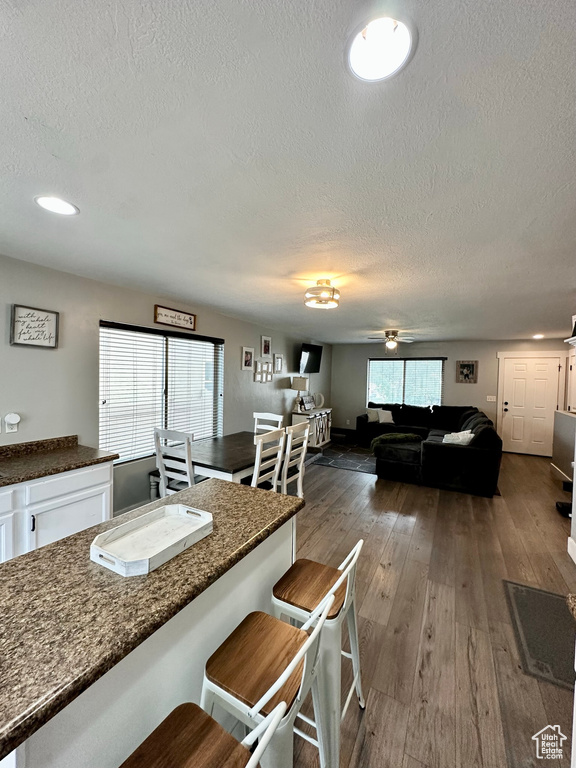 Dining space featuring a textured ceiling, ceiling fan, and dark hardwood / wood-style floors