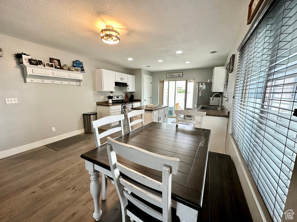 Dining space with sink, a textured ceiling, and hardwood / wood-style floors