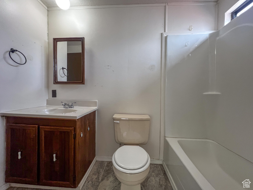 Full bathroom featuring bathing tub / shower combination, vanity, tile patterned floors, and toilet