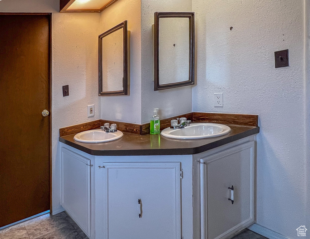 Bathroom featuring tile patterned flooring and dual bowl vanity