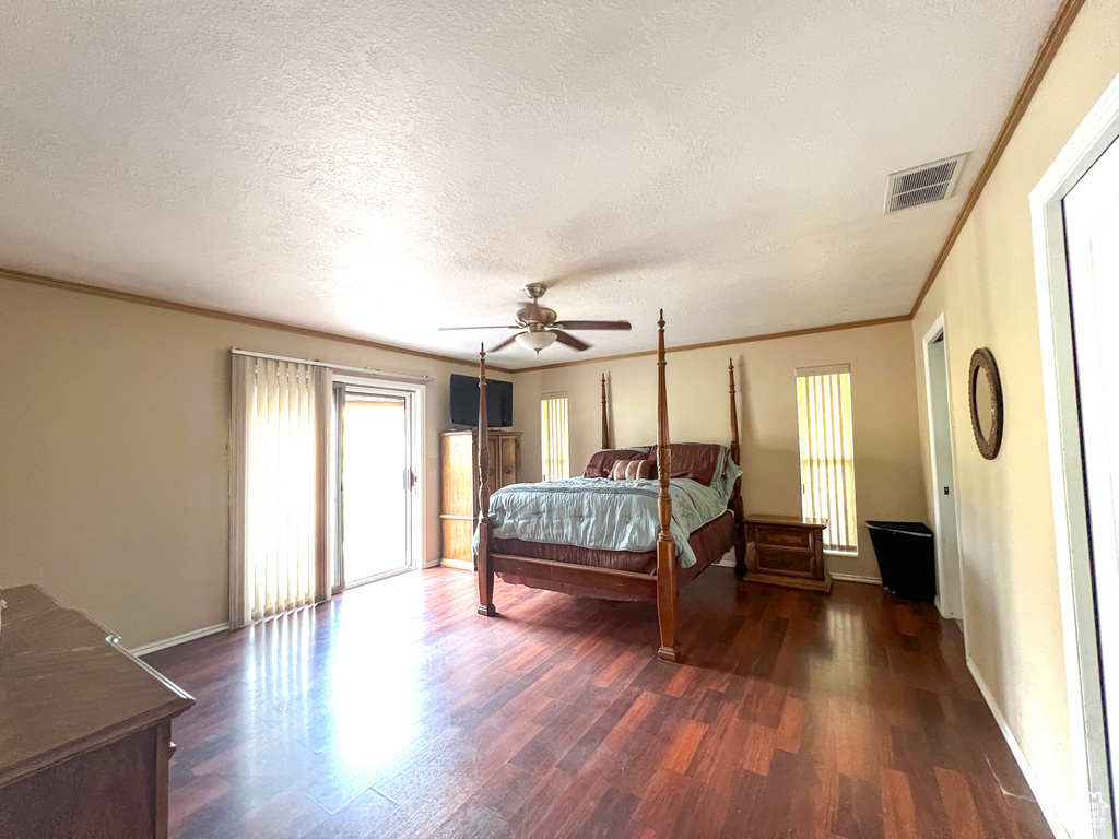 Bedroom with ornamental molding, a textured ceiling, ceiling fan, and hardwood / wood-style floors