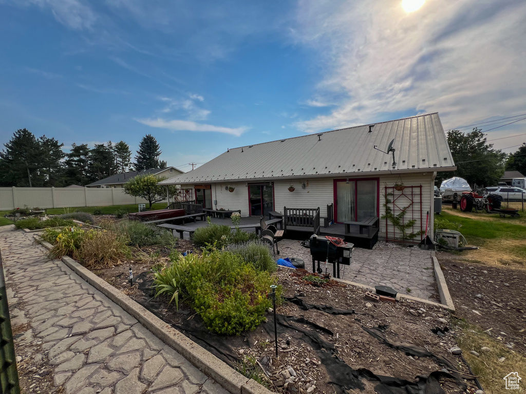 Rear view of house with an outdoor hangout area, a patio area, and a wooden deck