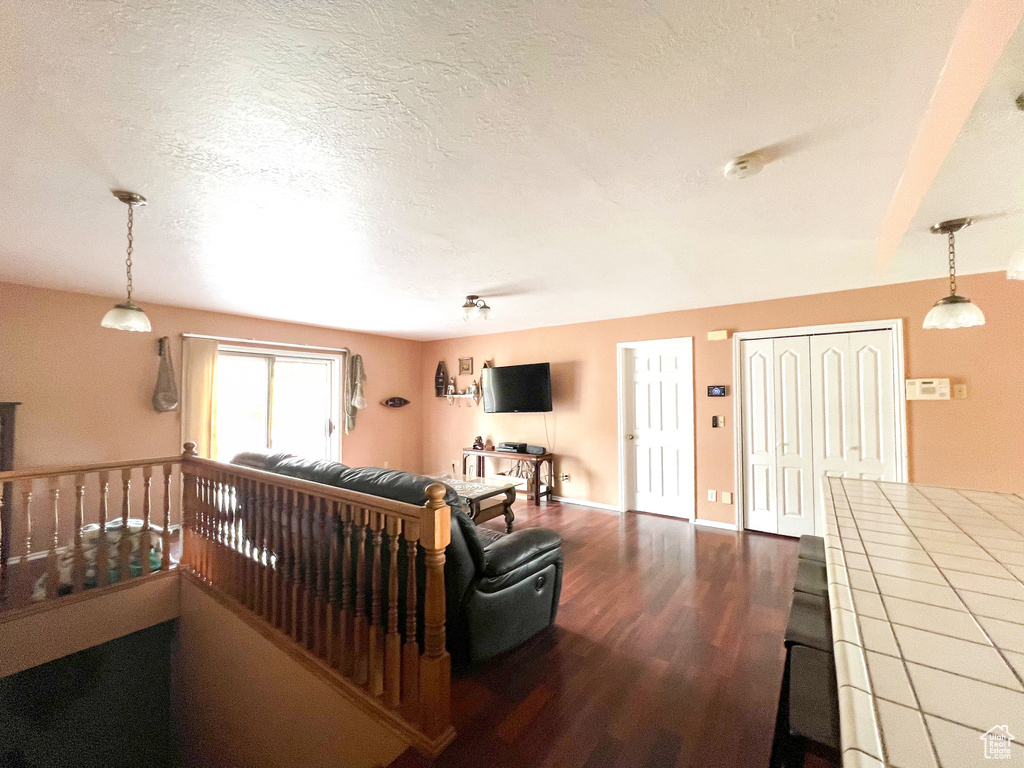 Living room with a textured ceiling and hardwood / wood-style floors