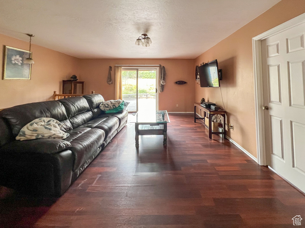 Living room featuring dark wood-type flooring and a textured ceiling