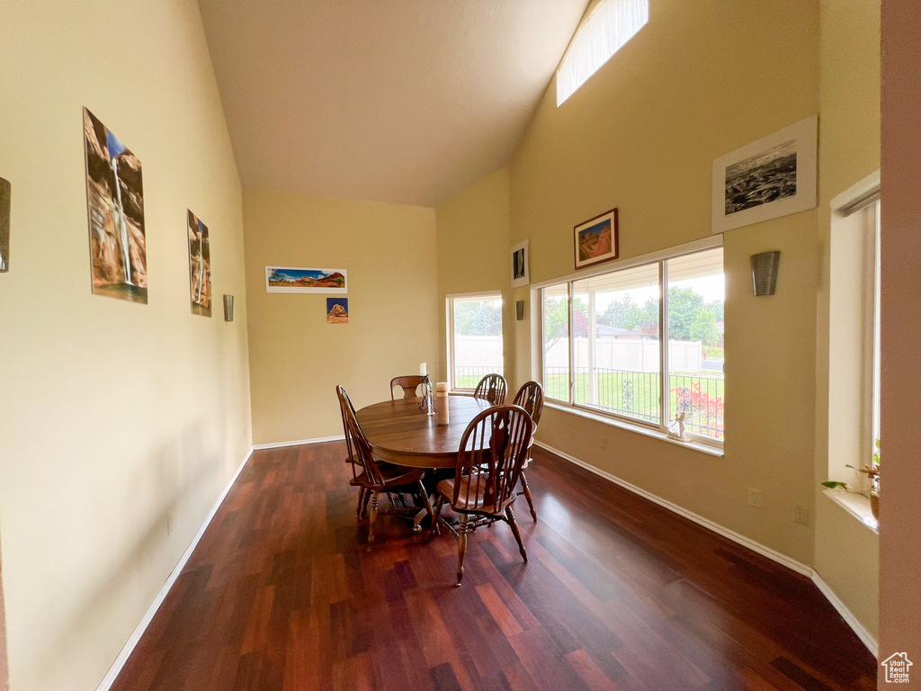 Dining space featuring high vaulted ceiling and hardwood / wood-style floors