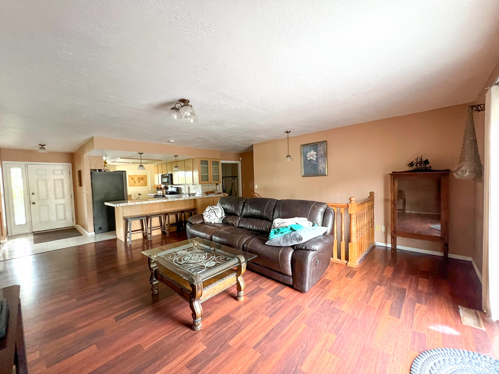 Living room with ceiling fan and hardwood / wood-style floors