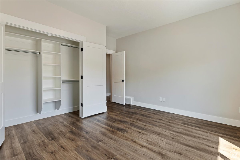 Unfurnished bedroom featuring hardwood / wood-style flooring and a closet