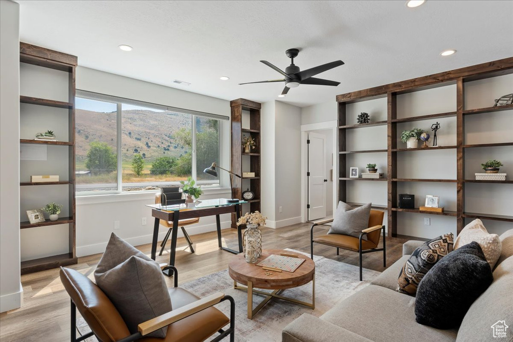 Living room featuring a mountain view, ceiling fan, and light wood-type flooring