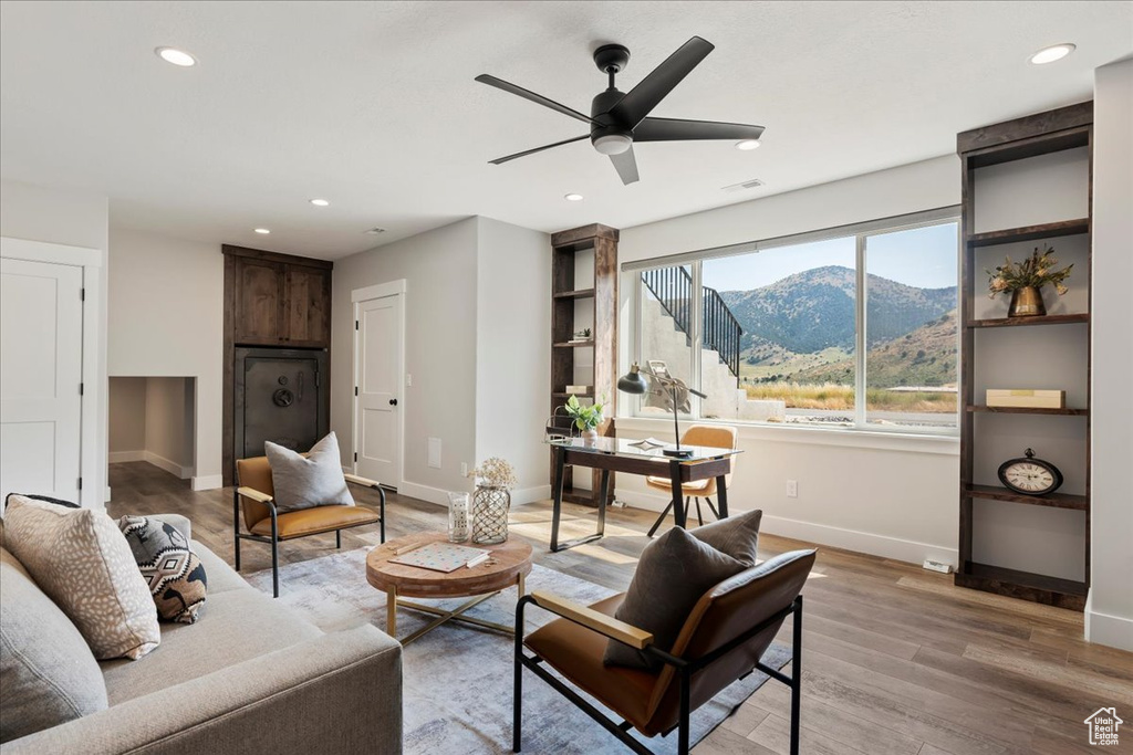 Living room with a mountain view, hardwood / wood-style flooring, and ceiling fan