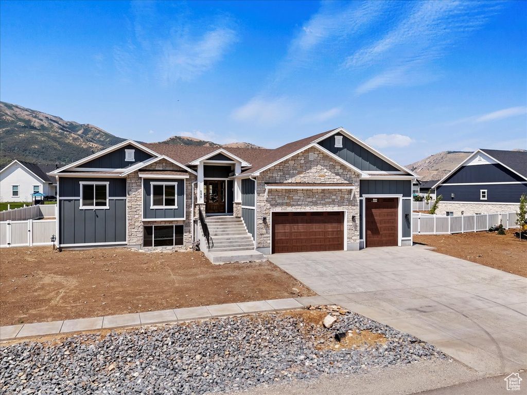 View of front of house with a mountain view and a garage