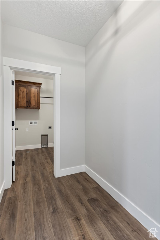 Empty room with dark wood-type flooring and a textured ceiling