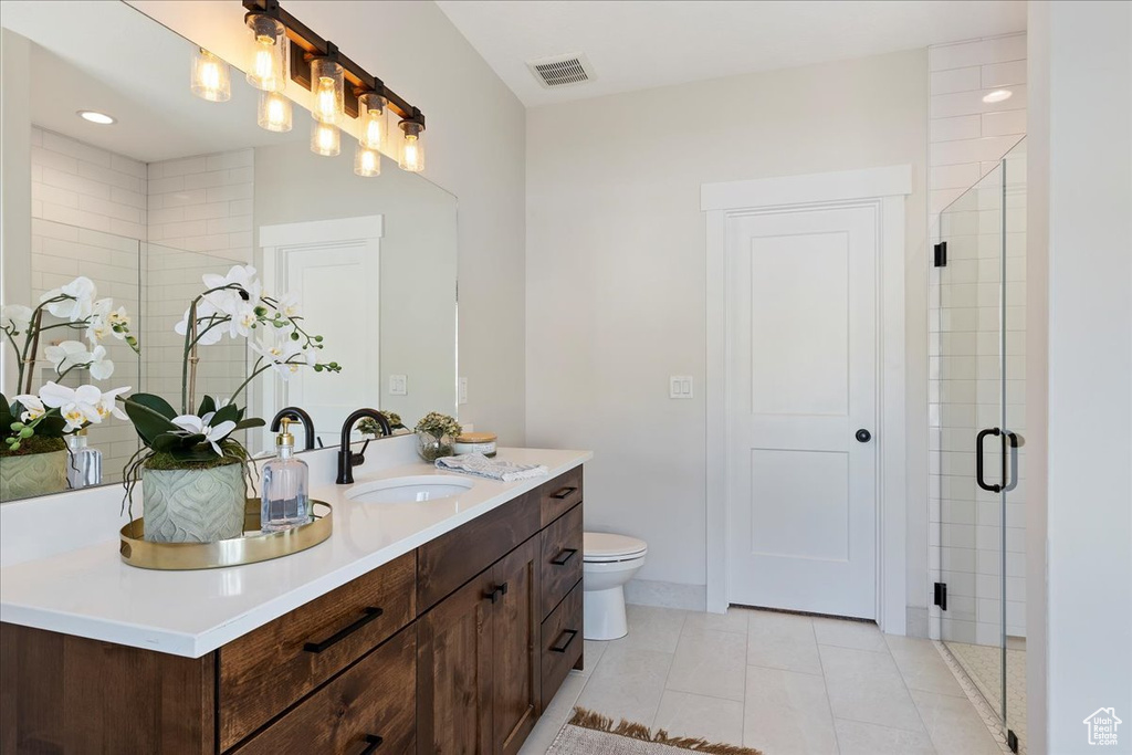 Bathroom featuring walk in shower, tile patterned floors, toilet, and vanity