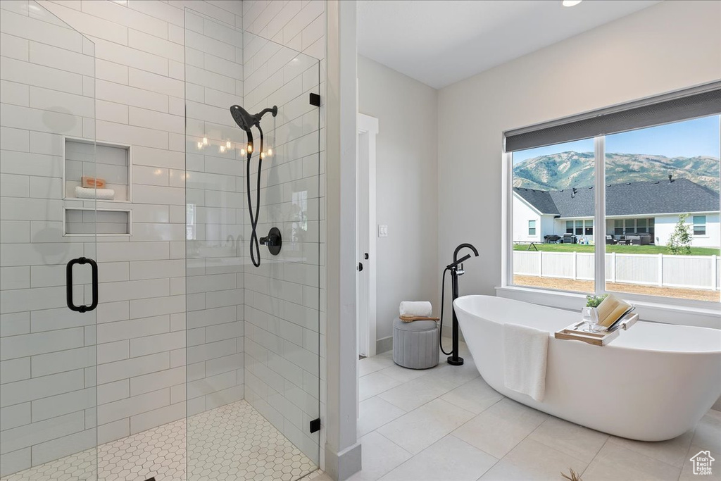 Bathroom featuring tile patterned flooring and shower with separate bathtub