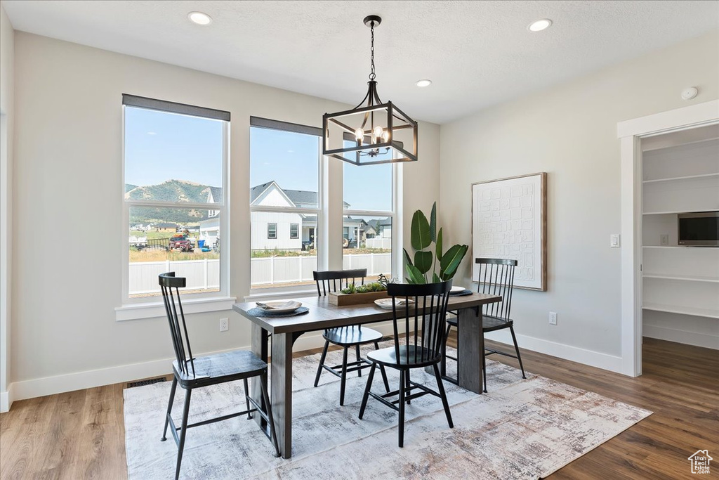 Dining area with light wood-type flooring and a chandelier