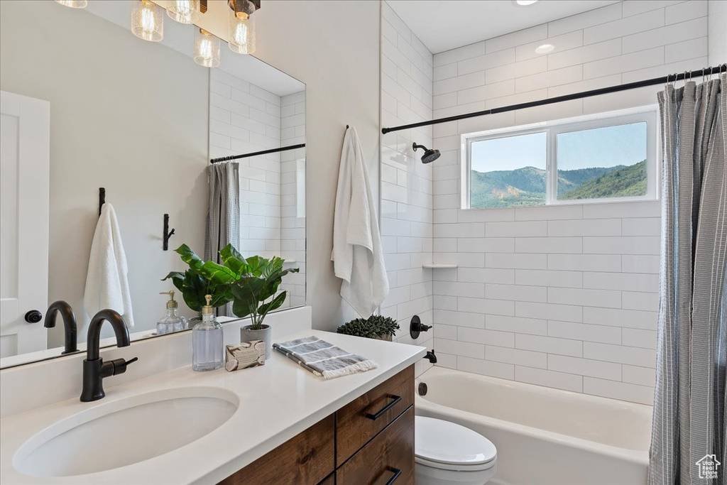 Full bathroom featuring toilet, vanity, and shower / tub combo with curtain