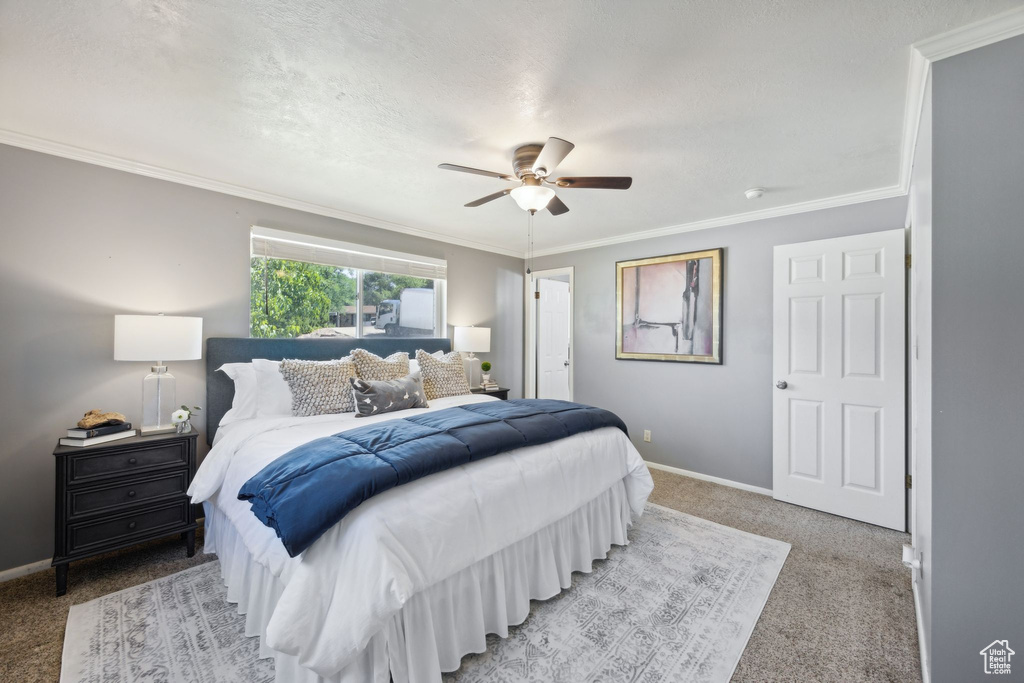 Bedroom featuring carpet flooring, ornamental molding, and ceiling fan