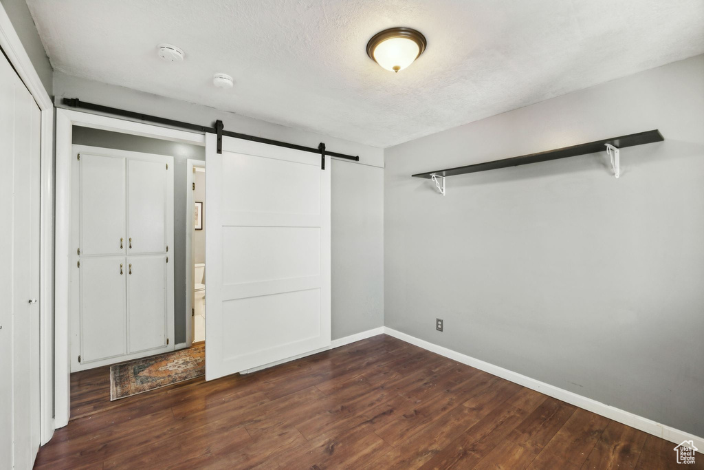 Spacious closet featuring a barn door and hardwood / wood-style floors