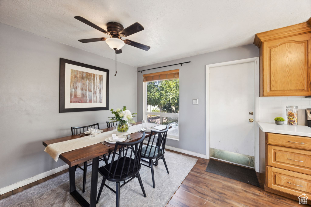 Dining space with ceiling fan and dark hardwood / wood-style floors