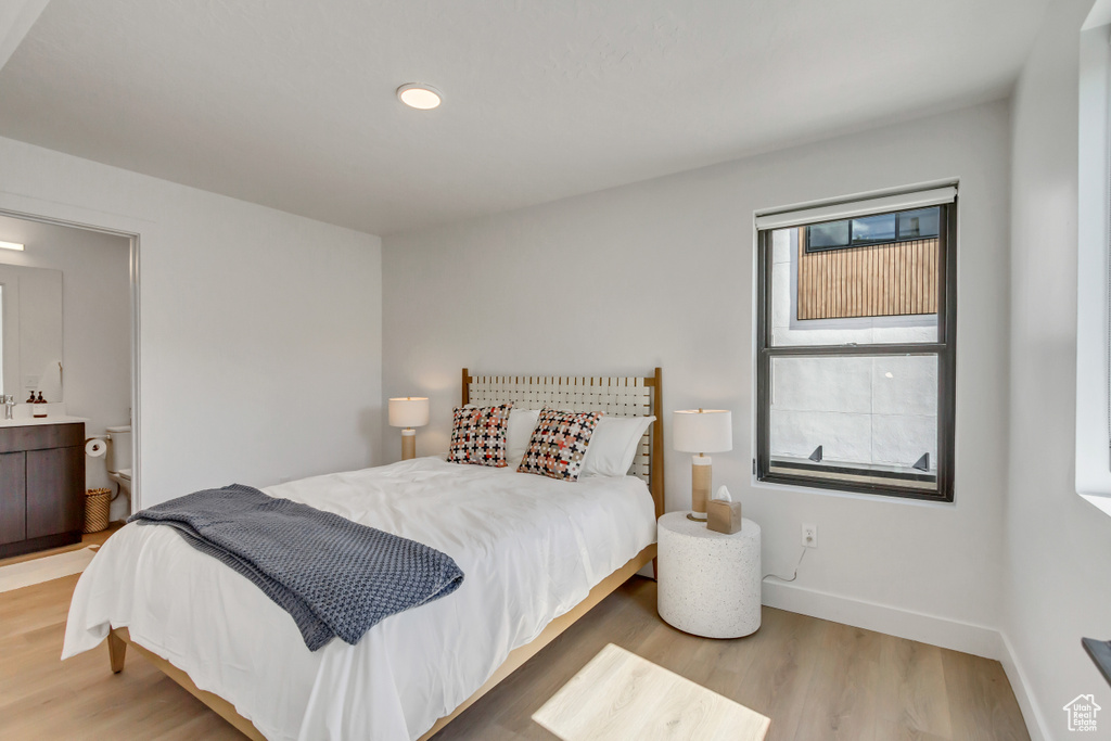 Bedroom with light hardwood / wood-style flooring and ensuite bathroom