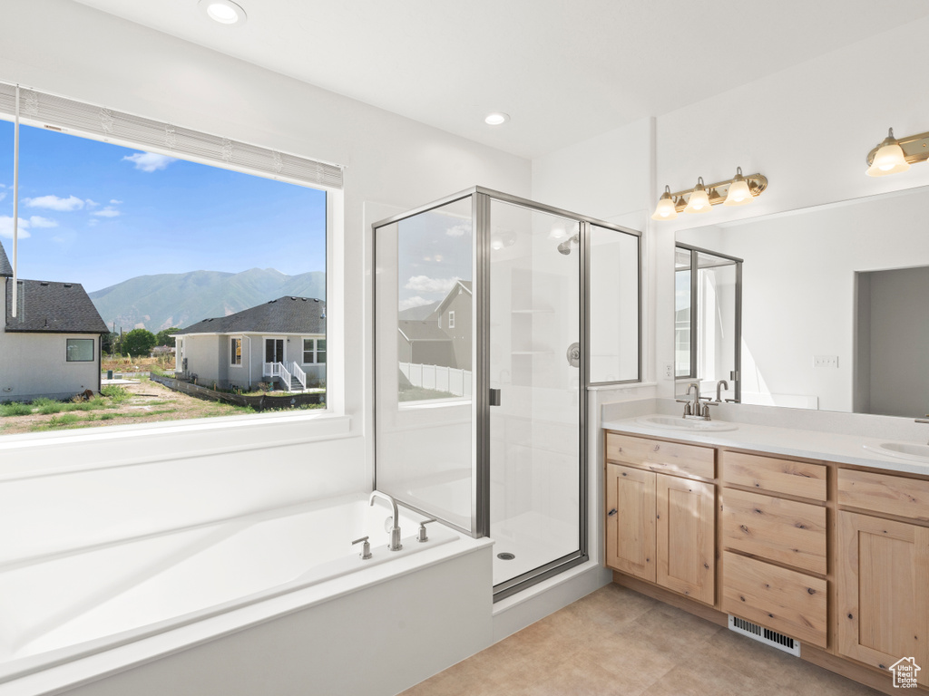 Bathroom with a mountain view, vanity, tile patterned floors, and shower with separate bathtub