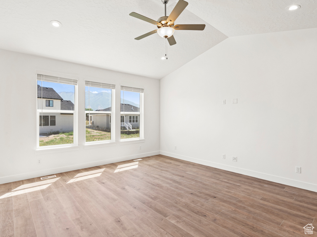 Unfurnished room featuring lofted ceiling, ceiling fan, and wood-type flooring