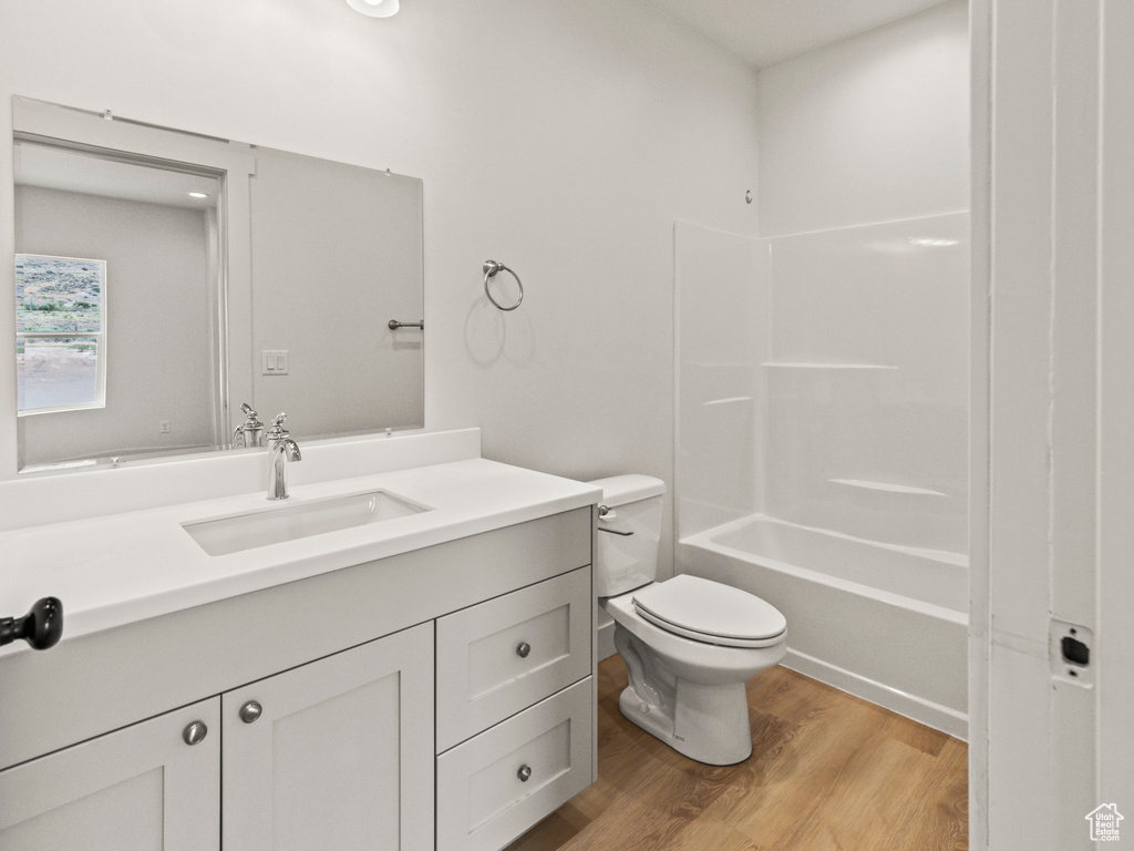 Full bathroom featuring vanity, shower / bathing tub combination, toilet, and hardwood / wood-style floors