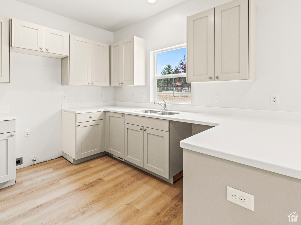 Kitchen featuring light hardwood / wood-style floors, sink, and gray cabinetry