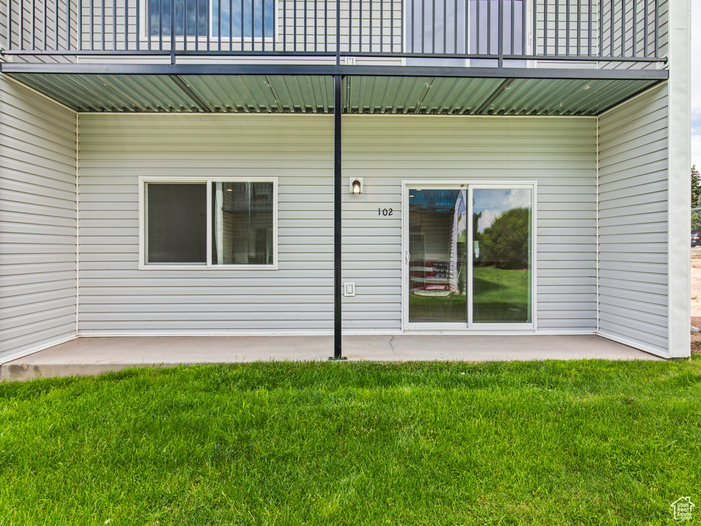 Doorway to property featuring a yard and a patio area