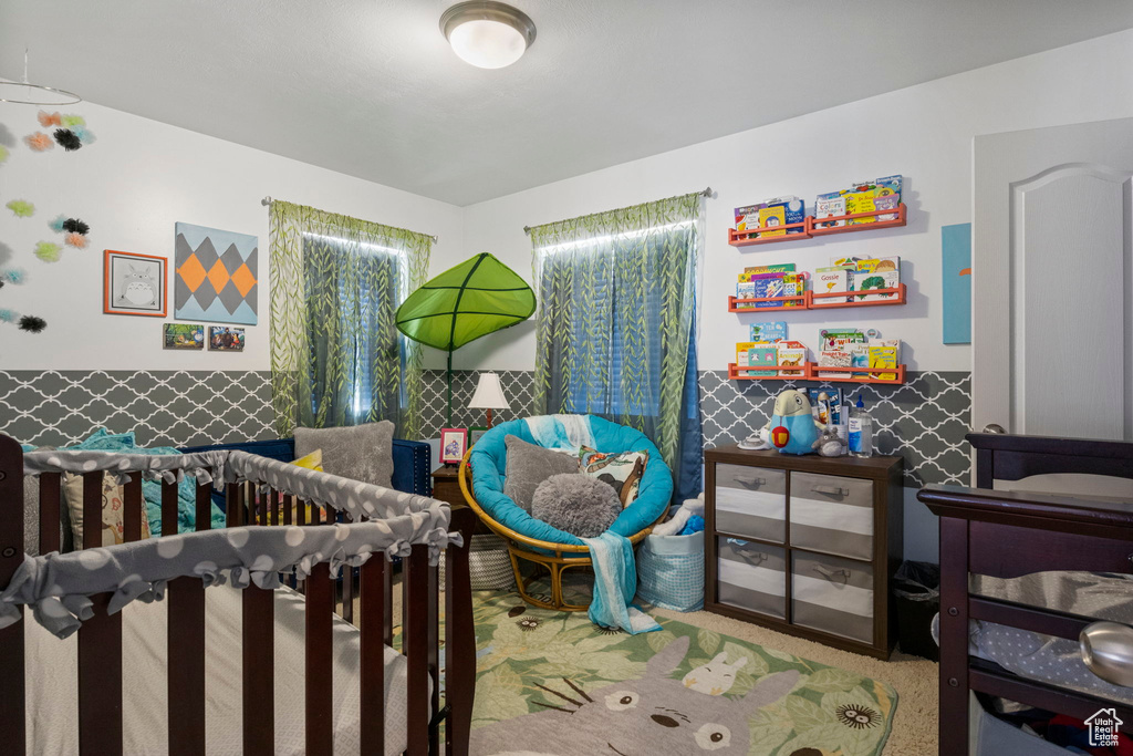 Bedroom with carpet, multiple windows, and a nursery area