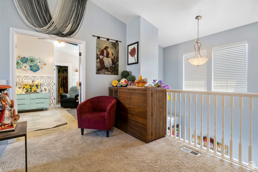 Living area with lofted ceiling, carpet, and ceiling fan