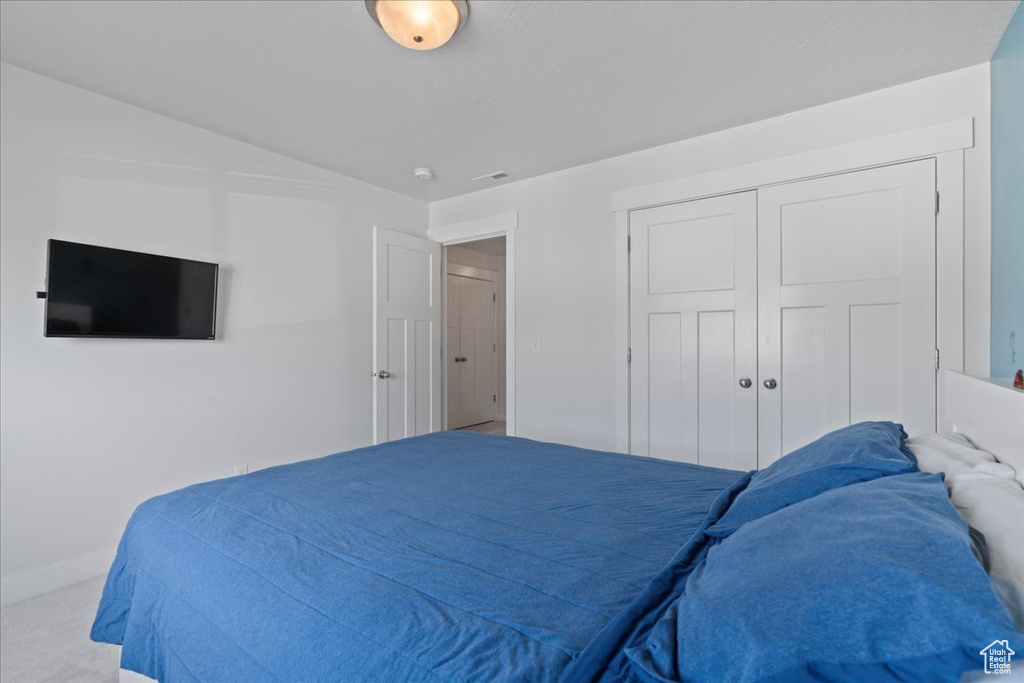 Bedroom featuring light carpet and a closet