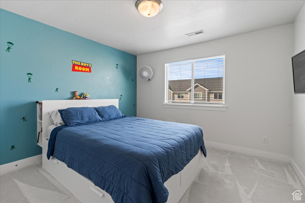 Bedroom with light colored carpet