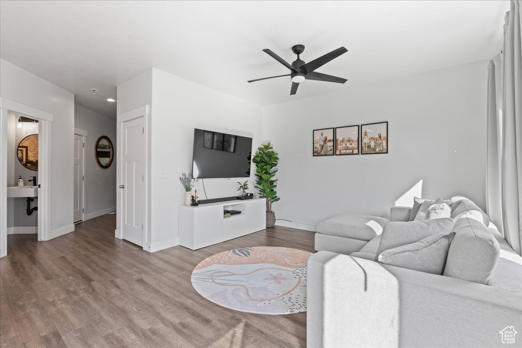 Living room with sink, ceiling fan, and wood-type flooring