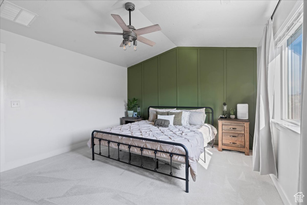 Bedroom with light colored carpet, lofted ceiling, and ceiling fan