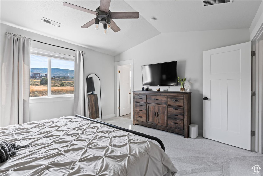 Carpeted bedroom with lofted ceiling and ceiling fan