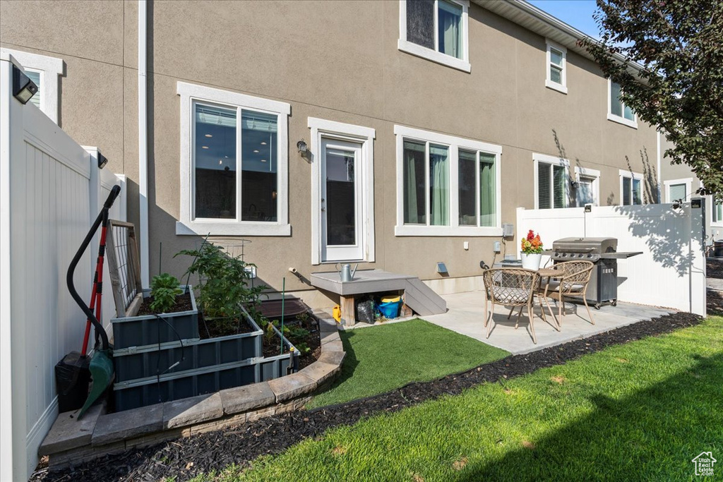 Rear view of house featuring a patio area and a lawn