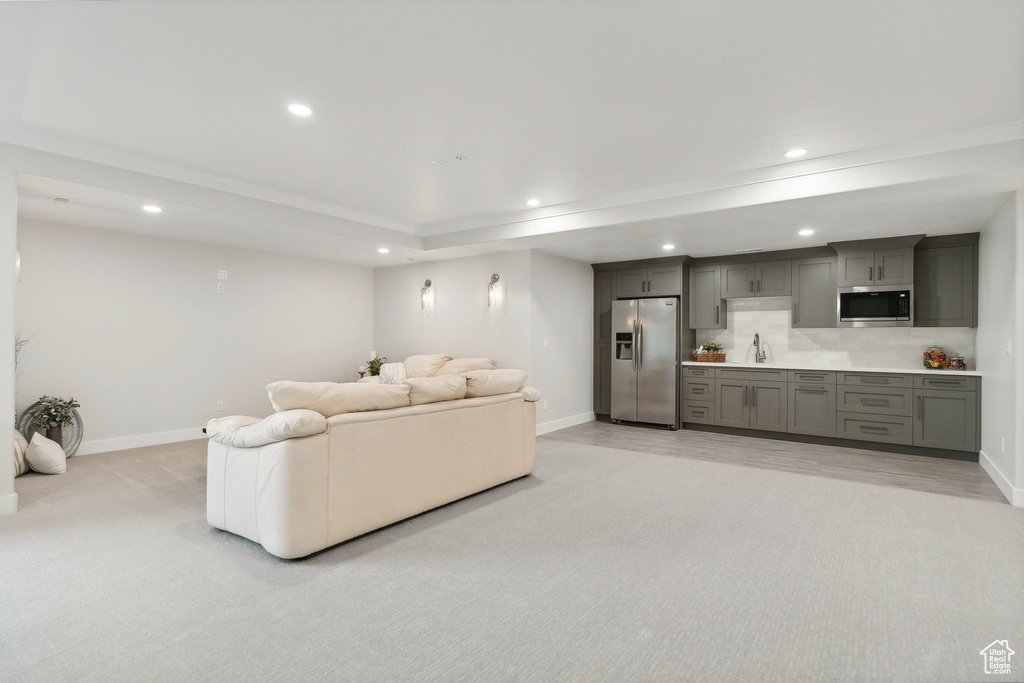 Carpeted living room with sink and a raised ceiling